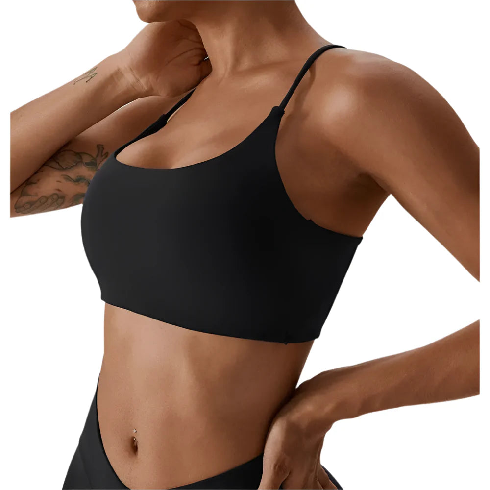 Person wearing a black sports bra against a neutral background